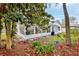 Exterior of the home featuring the sun room addition, a manicured lawn, and mature landscaping at 7107 Pond View Ct, Spring Hill, FL 34606