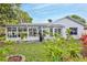 The exterior of the home features a sun room addition, manicured lawn and mature landscaping at 7107 Pond View Ct, Spring Hill, FL 34606