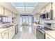 Bright kitchen with stainless steel appliances, white cabinetry, and a view into the dining area at 7107 Pond View Ct, Spring Hill, FL 34606