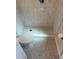 Stylish bathroom featuring patterned tile flooring, a walk-in shower, and elegant fixtures at 7336 Ivory Ter, New Port Richey, FL 34655