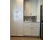 Pantry with white cabinets and gold hardware, open shelving, and stainless steel fridge at 7336 Ivory Ter, New Port Richey, FL 34655