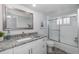 Bathroom featuring a granite countertop vanity and tiled shower with glass doors at 8251 Brent St # 918, Port Richey, FL 34668