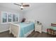 Cozy bedroom featuring a white-frame bed, shuttered windows, and ceiling fan at 8251 Brent St # 918, Port Richey, FL 34668