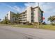 Multi-story condominium building showcasing balconies, mature palm trees, and well-maintained landscaping at 8251 Brent St # 918, Port Richey, FL 34668