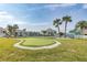 Well-maintained putting green surrounded by palm trees, offering a relaxing recreational space in the community at 8251 Brent St # 918, Port Richey, FL 34668