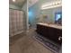 Well-lit bathroom featuring double sinks, a shower, and tile flooring at 8405 Blue Rock Dr, New Port Richey, FL 34653