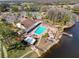 Stunning aerial view of the community pool, tennis courts, and lakefront amenities at 9321 Whitstone Ct, New Port Richey, FL 34655