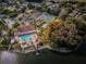 Aerial showcasing the community pool, tennis courts, and lake access with a fishing pier at 9336 Cape Charles Ave, New Port Richey, FL 34655