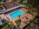 Aerial view of the community pool, clubhouse with ample seating, and lush landscaping, perfect for outdoor activities at 9336 Cape Charles Ave, New Port Richey, FL 34655