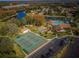 Community aerial featuring pool, tennis courts, shuffleboard, and lake in a park-like setting at 9336 Cape Charles Ave, New Port Richey, FL 34655