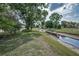 View of the backyard featuring lush greenery and a creek running through the property at 9336 Cape Charles Ave, New Port Richey, FL 34655
