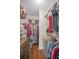 Walk-in closet featuring wood floors and an adjustable hanging system and shelving at 9336 Cape Charles Ave, New Port Richey, FL 34655