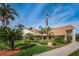 Beautiful clubhouse with manicured landscaping, palm trees, and an American flag, welcoming residents and visitors at 9336 Cape Charles Ave, New Port Richey, FL 34655