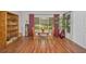 Bright dining area with hardwood floors, a table set for two, and large windows overlooking the backyard at 9336 Cape Charles Ave, New Port Richey, FL 34655