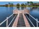 Lakefront property featuring a wooden dock with safety railings and textured walking slats at 9336 Cape Charles Ave, New Port Richey, FL 34655