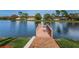 Wooden dock extending into a serene lake with lush landscaping, offering a peaceful retreat at 9336 Cape Charles Ave, New Port Richey, FL 34655