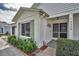 The home's entrance features a charming white brick facade, well-kept landscaping, and an inviting doorway at 9336 Cape Charles Ave, New Port Richey, FL 34655