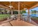 Covered gazebo featuring seating, ceiling fans, and picturesque views of the surrounding lake and lush landscaping at 9336 Cape Charles Ave, New Port Richey, FL 34655