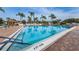 Sparkling community pool area with palm trees, lounge chairs, and clear blue water, perfect for relaxation at 9336 Cape Charles Ave, New Port Richey, FL 34655