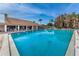 Large community pool with plenty of seating and an expansive deck area surrounded by mature landscaping at 9336 Cape Charles Ave, New Port Richey, FL 34655