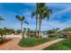 Beautiful waterfront view featuring lush landscaping, palm trees, and a tranquil pond with a fountain at 9336 Cape Charles Ave, New Port Richey, FL 34655