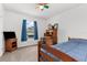 Cozy bedroom with a blue comforter, wooden furniture, and a ceiling fan at 10399 Elgin Blvd, Spring Hill, FL 34608