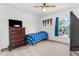 Bedroom featuring a bed, dresser, TV, ceiling fan, and a window with natural light at 10399 Elgin Blvd, Spring Hill, FL 34608