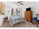 Bright bedroom features neutral walls, carpet floors, and a striped quilt on the bed at 10399 Elgin Blvd, Spring Hill, FL 34608