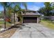 Charming two-story home with a two-car garage, a well-maintained lawn and a mature palm tree at 10399 Elgin Blvd, Spring Hill, FL 34608