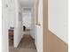 Hallway featuring neutral carpet, white walls with decorative niche and view to a bedroom at 10399 Elgin Blvd, Spring Hill, FL 34608