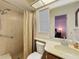 Bathroom with a shower, neutral tile, and a vanity with a large mirror at 10635 Timber Ln, Port Richey, FL 34668