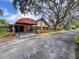 Inviting clubhouse entrance featuring well-manicured landscaping and a covered walkway at 10635 Timber Ln, Port Richey, FL 34668