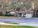 Charming single-story home featuring stone accents, mature trees, and a well-maintained lawn at 10635 Timber Ln, Port Richey, FL 34668