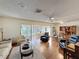 Bright living room with hardwood floors, sliding glass doors, and comfortable seating at 10635 Timber Ln, Port Richey, FL 34668