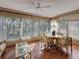 Bright sunroom featuring large windows, hardwood floors, a ceiling fan, and comfortable seating at 10635 Timber Ln, Port Richey, FL 34668