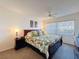 Calm bedroom featuring a large bed, ceiling fan, ample natural light, and neutral tones at 10635 Timber Ln, Port Richey, FL 34668