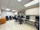 Bright office area featuring multiple workstations, modern computer setups, and ample storage cabinets at 10635 Timber Ln, Port Richey, FL 34668
