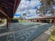 Outdoor shuffleboard courts ready for play, set amidst lush landscaping and covered seating areas at 10635 Timber Ln, Port Richey, FL 34668
