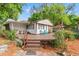 View of a home with a wooden deck, outdoor furniture, and lush landscaping at 11326 Minnieola Dr, New Port Richey, FL 34654