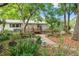 Landscaped backyard with a deck, patio furniture, and lush greenery creating a private oasis at 11326 Minnieola Dr, New Port Richey, FL 34654