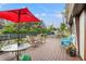 Outdoor deck features seating, a table, and a red umbrella for shade in the backyard at 11326 Minnieola Dr, New Port Richey, FL 34654
