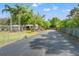Exterior showcases a long driveway, fencing, mature trees, and lawn in the yard at 11326 Minnieola Dr, New Port Richey, FL 34654