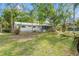 Exterior of a home with mature trees and landscaping, providing shade and privacy at 11326 Minnieola Dr, New Port Richey, FL 34654