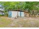 View of the shed with multiple doors and a picnic table, perfect for storage at 11326 Minnieola Dr, New Port Richey, FL 34654