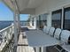 Expansive balcony with table and chairs, offering water views from the sliding glass doors and white decorative railing at 121 Augusta Ave, Palm Harbor, FL 34683