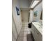 Bathroom with tiled floors, white vanity, black toilet, wainscoting and a shower/tub at 121 Augusta Ave, Palm Harbor, FL 34683