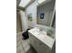 Bright bathroom features tiled floors, white vanity, black fixtures and wainscoting at 121 Augusta Ave, Palm Harbor, FL 34683