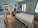 Bedroom featuring an ensuite bathroom, shuttered windows, wood floors, and seating area at 121 Augusta Ave, Palm Harbor, FL 34683
