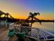 Deck view overlooking the water at sunset, featuring palm trees, evoking a sense of relaxation and tropical charm at 121 Augusta Ave, Palm Harbor, FL 34683