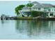 Waterfront home featuring a dock, boat lift, covered patio, and views of the bay at 121 Augusta Ave, Palm Harbor, FL 34683